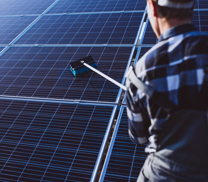Man worker in the firld by the solar panels